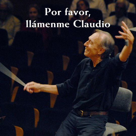 Claudio Abbado smiling as he conducts with a baton.